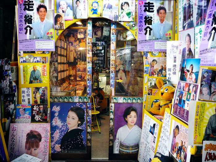 Entrada d'una botiga de música, amb cartells de cantants d'enka
